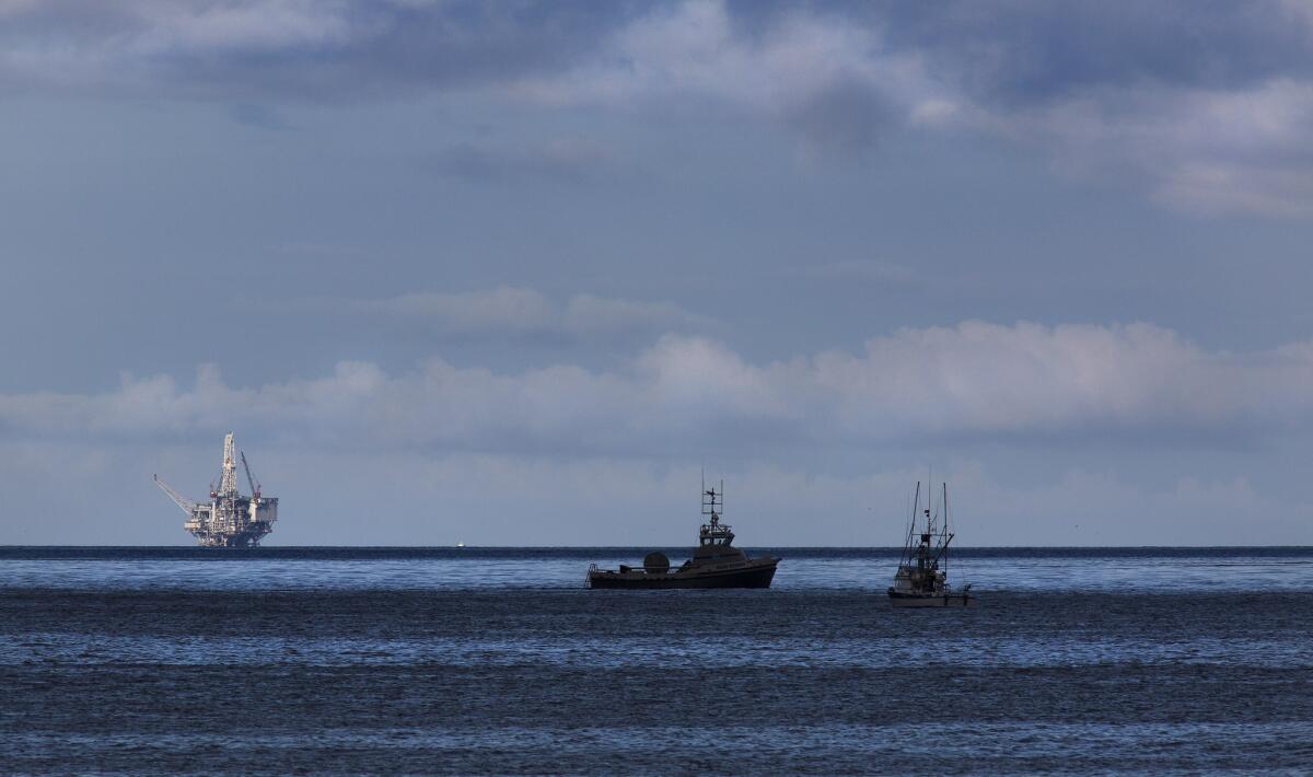 Oil recovery and cleanup vessels ply the waters off of El Capitan State Beach near Santa Barbara on May 21, 2015. An oil drilling rig in the Santa Barbara Channel is on the horizon, left.