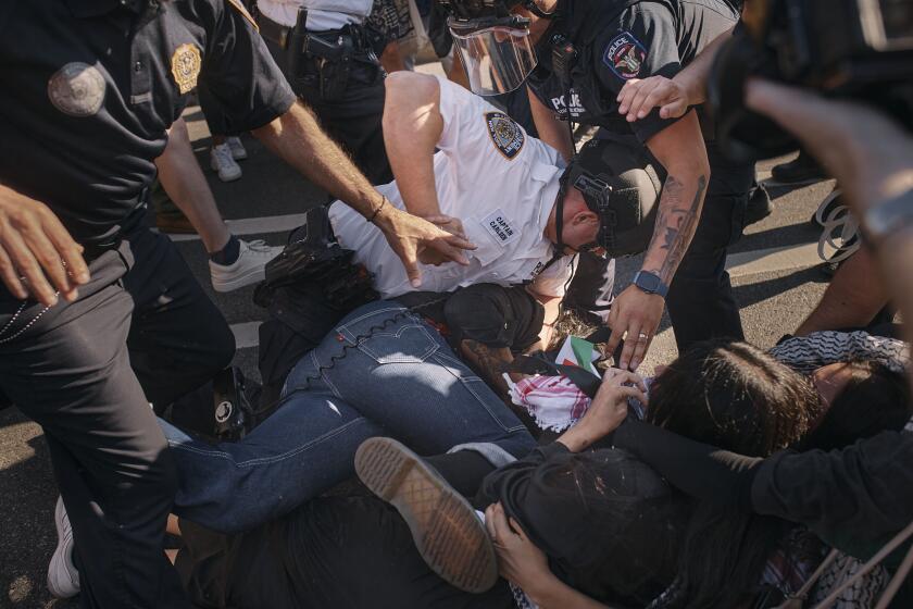 Un oficial de policía de la ciudad de Nueva York golpea a un manifestante propalestio tras llevarlo al suelo durante una protesta a favor de un cese al fuego permanente en Gaza, el viernes 31 de mayo de 2024, en el distrito de Brooklyn de Nueva York. (AP Foto/Andres Kudacki)