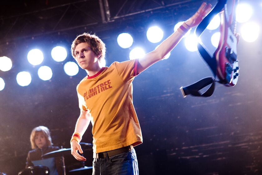 Michael Cera as Scott Pilgrim holding a guitar on a stage
