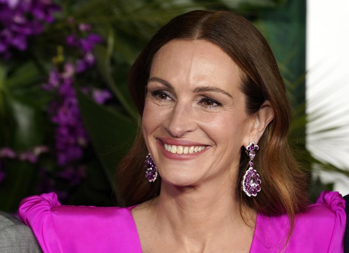 A smiling woman wearing a bright pink gown