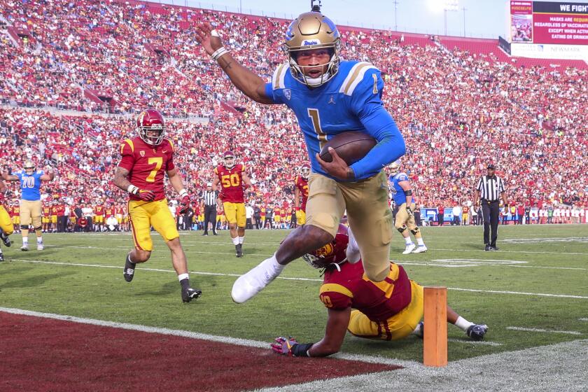 UCLA quarterback Dorian Thompson-Robinson runs past USC linebacker Ralen Goforth for a touchdown. 