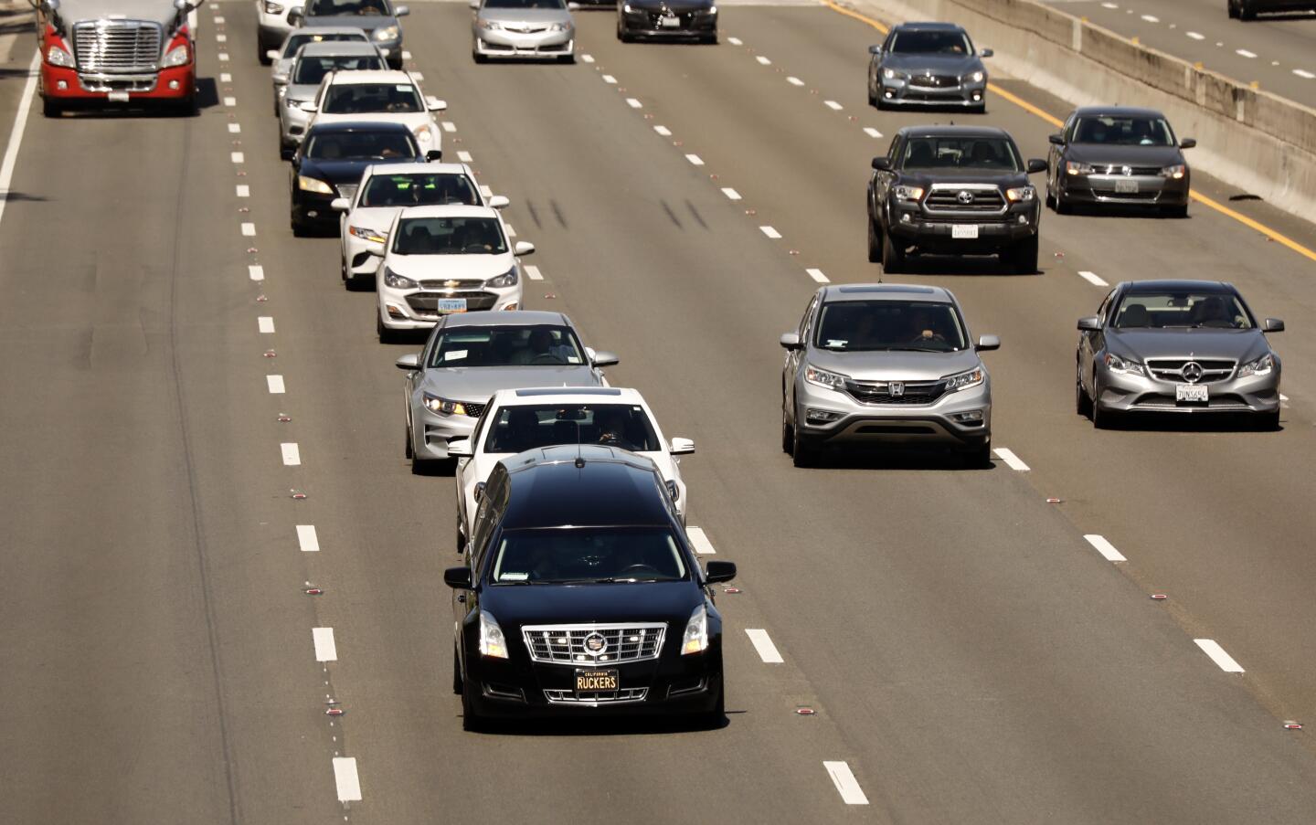 A hearse leads a procession of cars on the 101 Freeway toward downtown Los Angeles.