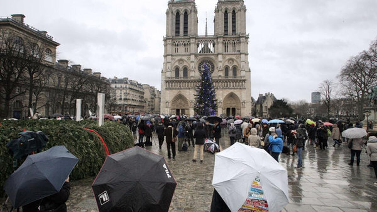 Mourners gather at the Notre Dame Cathedral in Paris to observe a minute of silence for victims of the Charlie Hebdo attack.