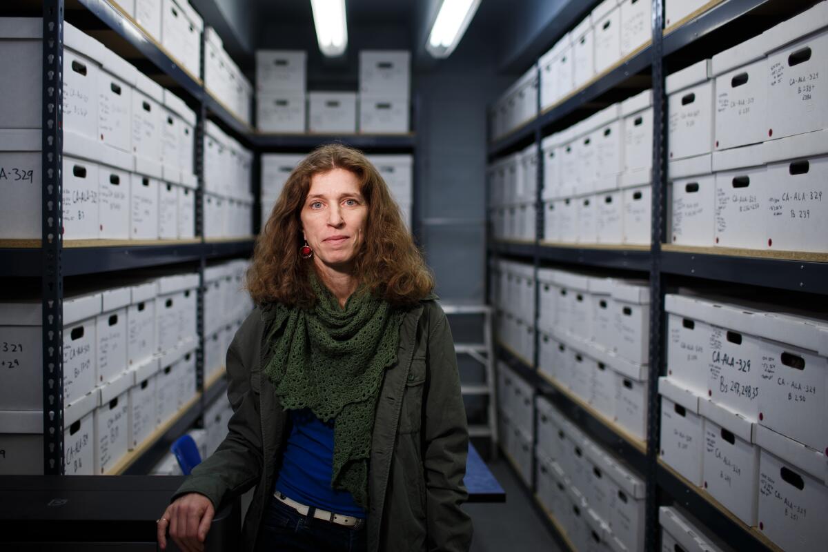 a woman in a closet full of file boxes