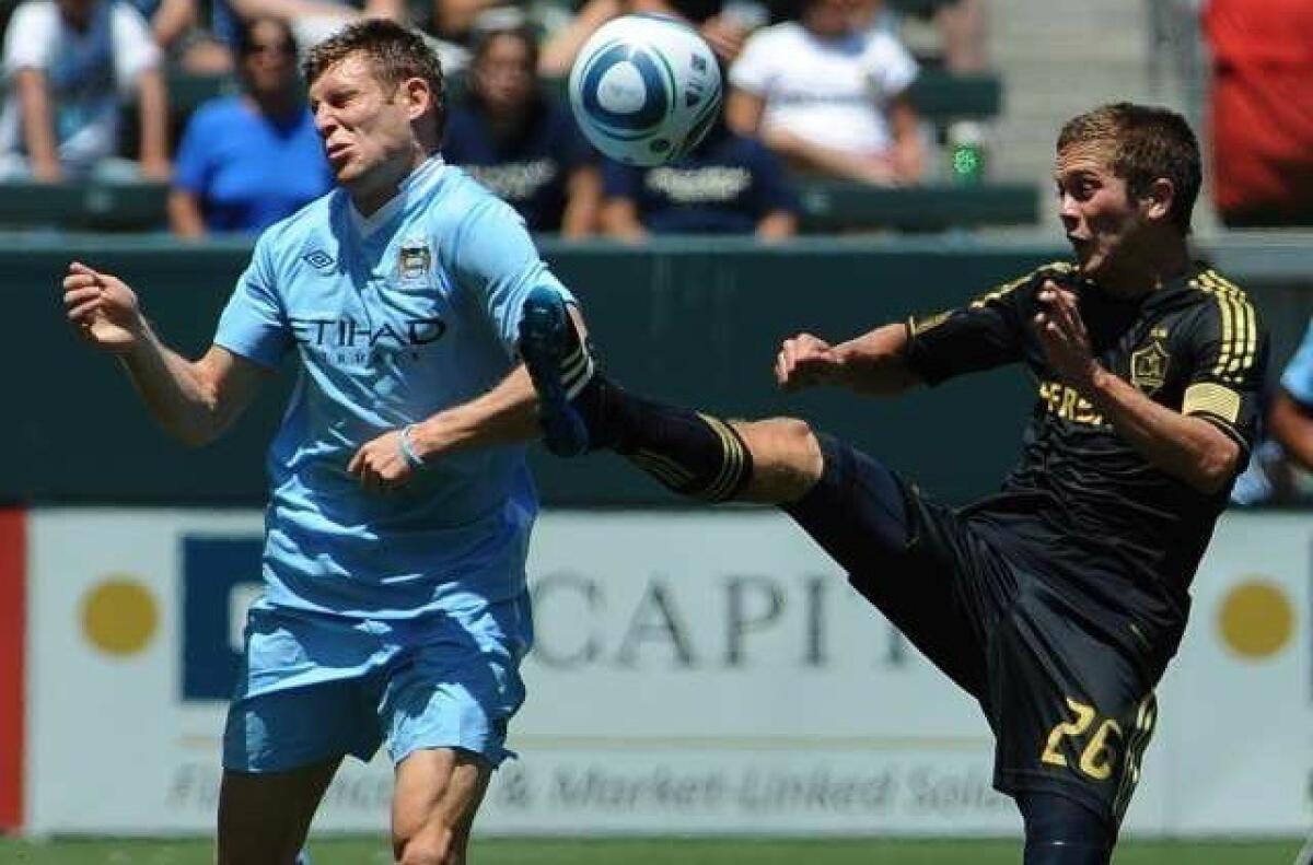 Michael Stephens, right, competes for the ball with Edin Dzeko of Manchester City during a July 2011 Galaxy game.