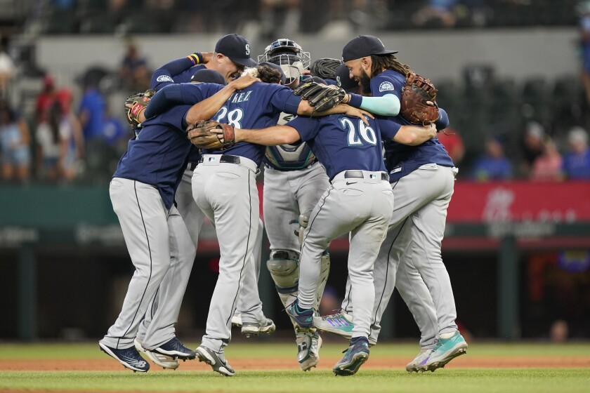 The Seattle Mariners dance in a circle after the final out of the baseball game against the Texas Rangers in Arlington, Texas, Sunday, July 17, 2022. The Mariners won 6-2. (AP Photo/LM Otero)