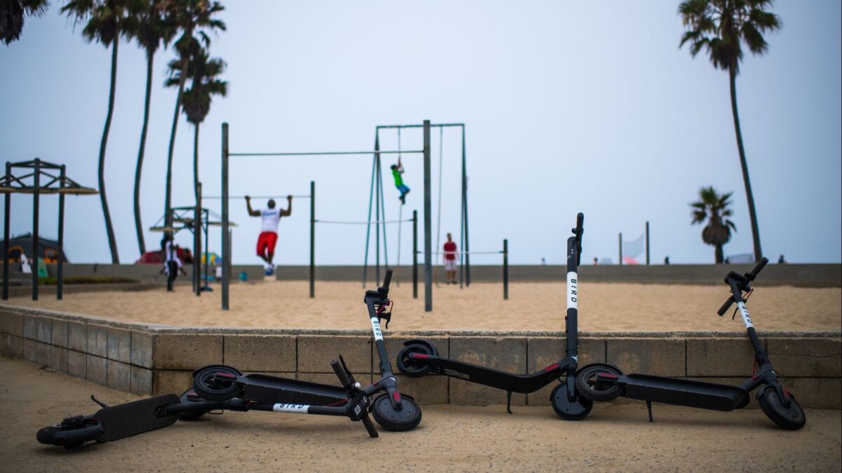 Electric scooters lie discarded along the Venice Beach boardwalk five months after the City Council voted to impose a ban on the devices in all Los Angeles neighborhoods.
