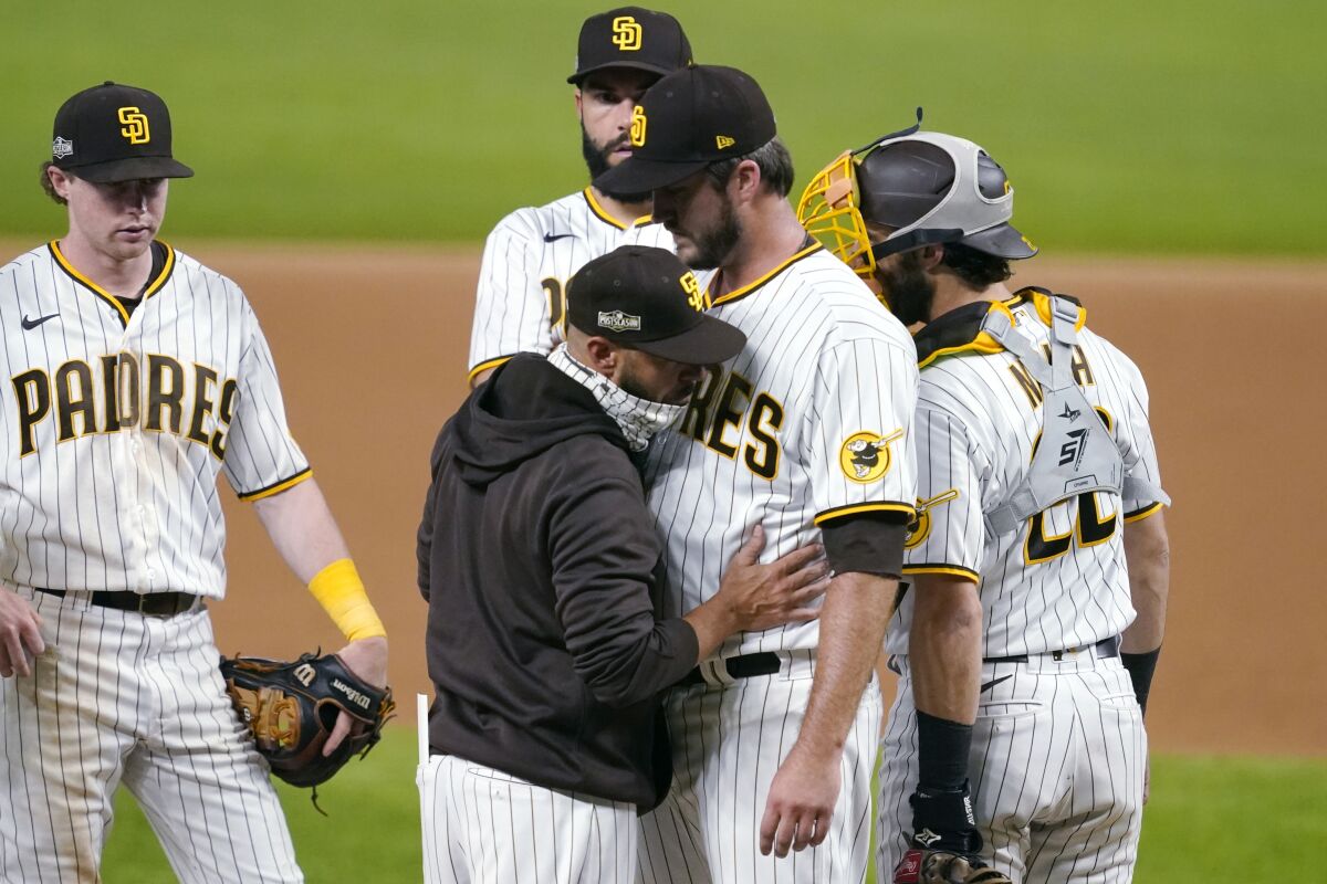 San Diego Padres manager Jayce Tingler, in jacket, takes pitcher Drew Pomeranz out of the game against the Los Angeles Dodgers during the eighth inning in Game 3 of a baseball National League Division Series Thursday, Oct. 8, 2020, in Arlington, Texas. (AP Photo/Tony Gutierrez)