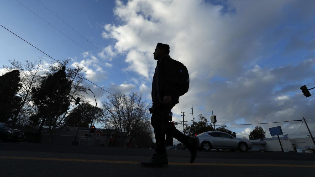 A homeless college student walks in Hayward, Calif. on March 1, 2018.