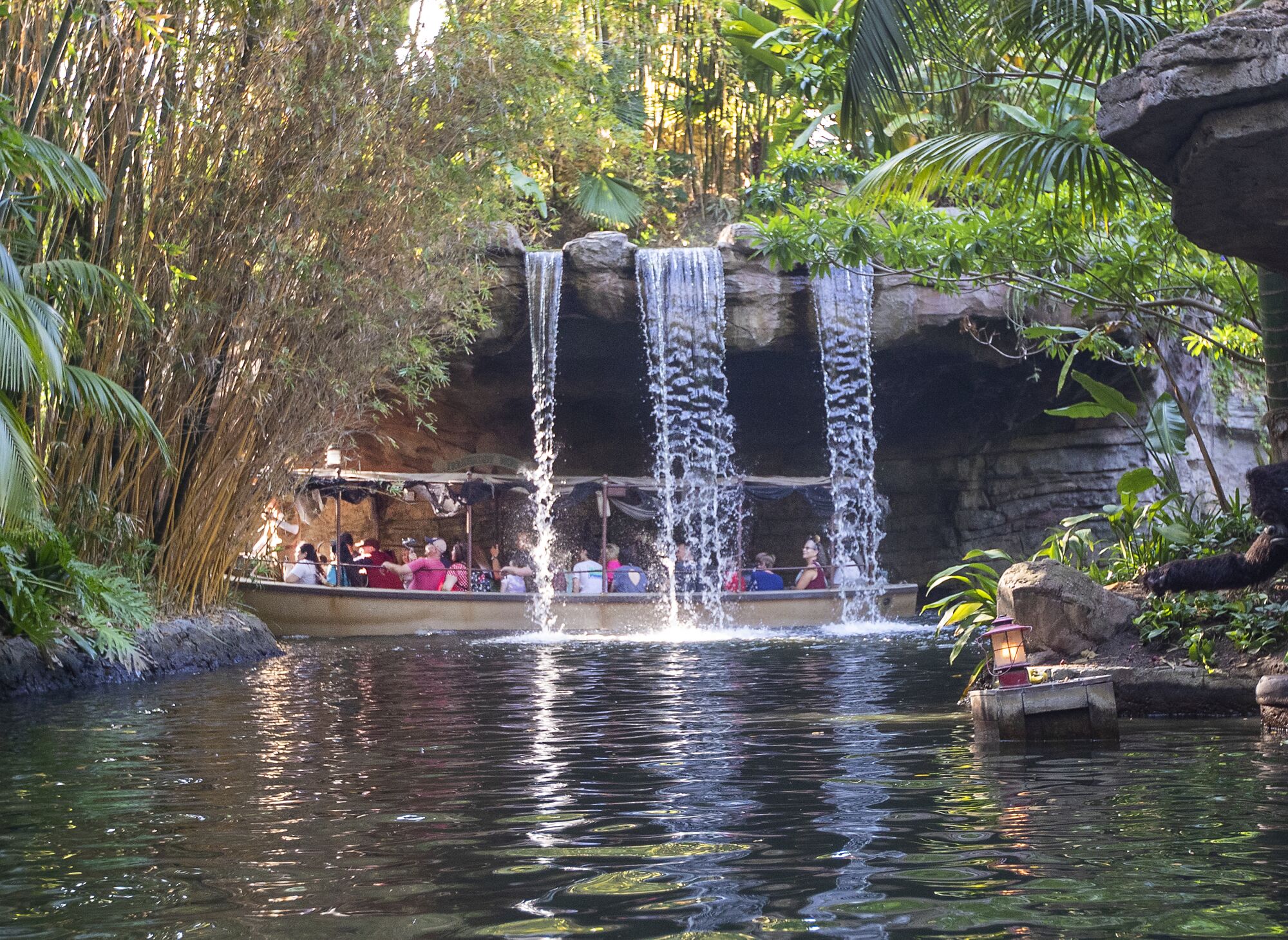 Riders pass under waterfalls at Schweitzer Falls during the Jungle Cruise ride.