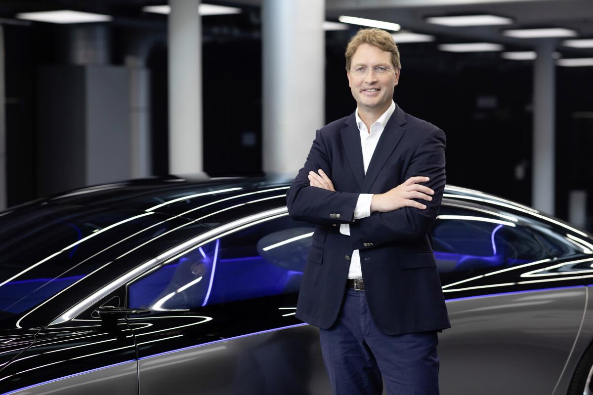Mercedes-Benz CEO Ola Källenius poses in front of a car