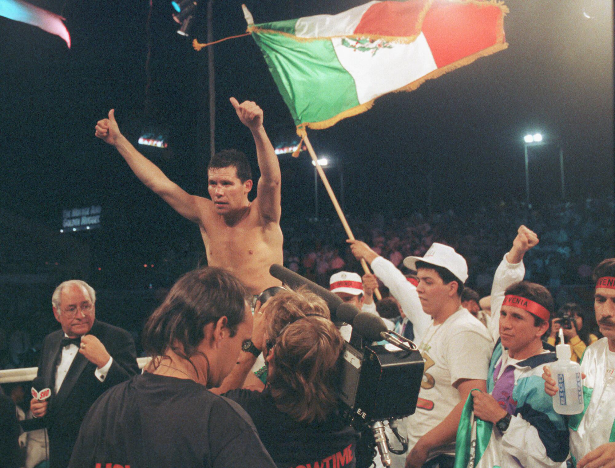 Julio César Chávez gets a victory ride around the ring with the Mexican flag with the victory. 