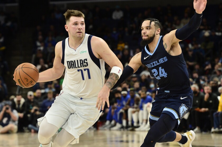 Dallas Mavericks guard Luka Doncic (77) is defended by Memphis Grizzlies forward Dillon Brooks (24) during the second half of an NBA basketball game Wednesday, Dec. 8, 2021, in Memphis, Tenn. (AP Photo/Brandon Dill)