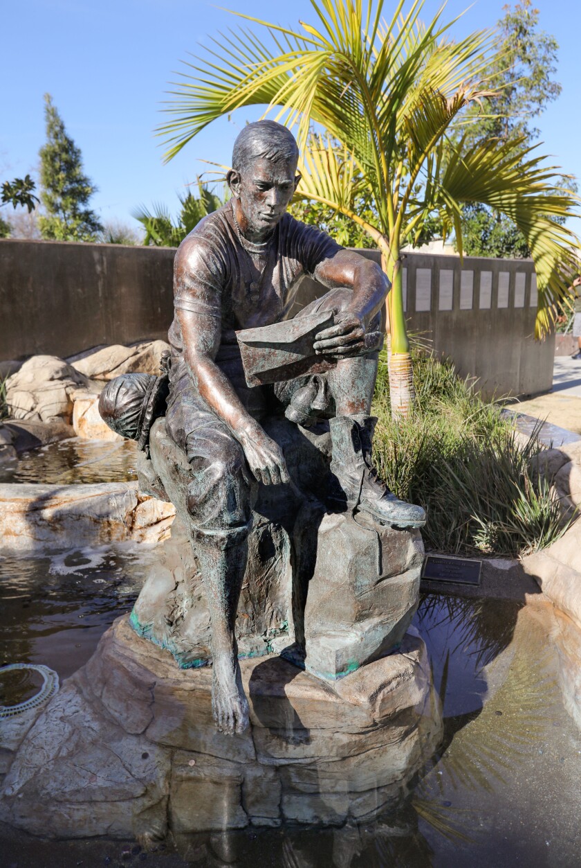 A sculpture of Vietnam War Marine Ernie Pinamonti reading a letter from home at Veterans Memorial Park in Vista.