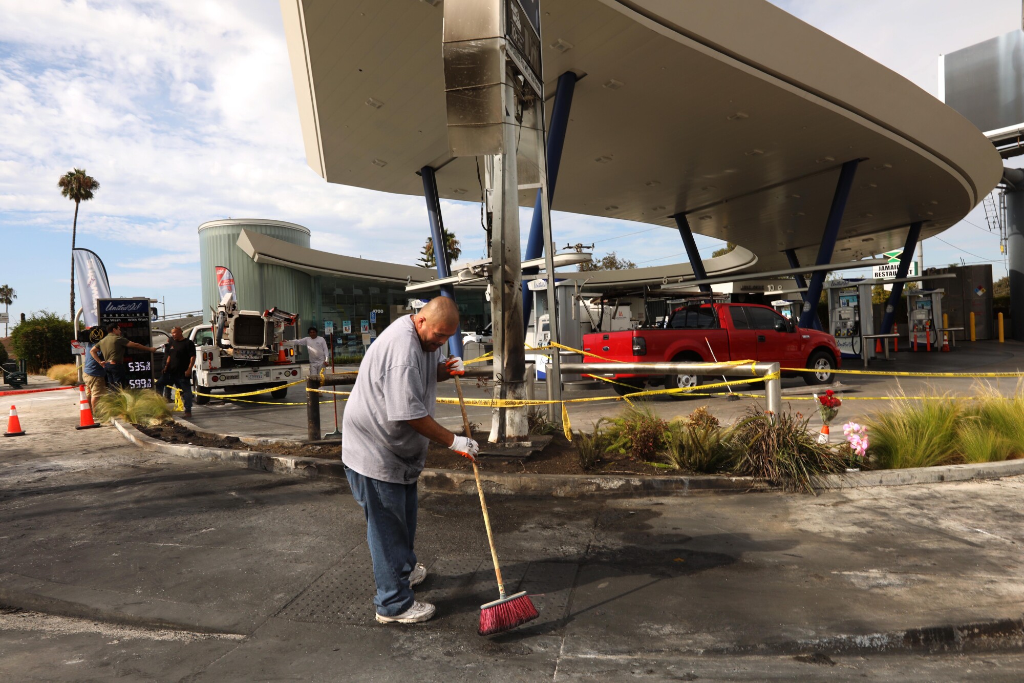 Photos: Prayers, memorial for five killed in fiery car crash... A man sweeps with a broom.