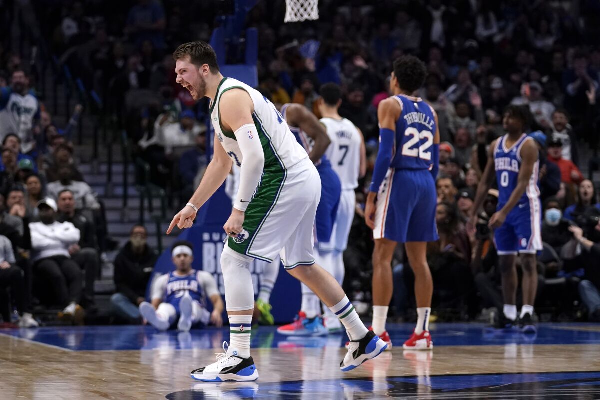 Dallas Mavericks' Luka Doncic celebrates a basket by Jalen Brunson during the second half of the team's NBA basketball game against the Philadelphia 76ers in Dallas, early Saturday, Feb. 5, 2022. (AP Photo/Tony Gutierrez)