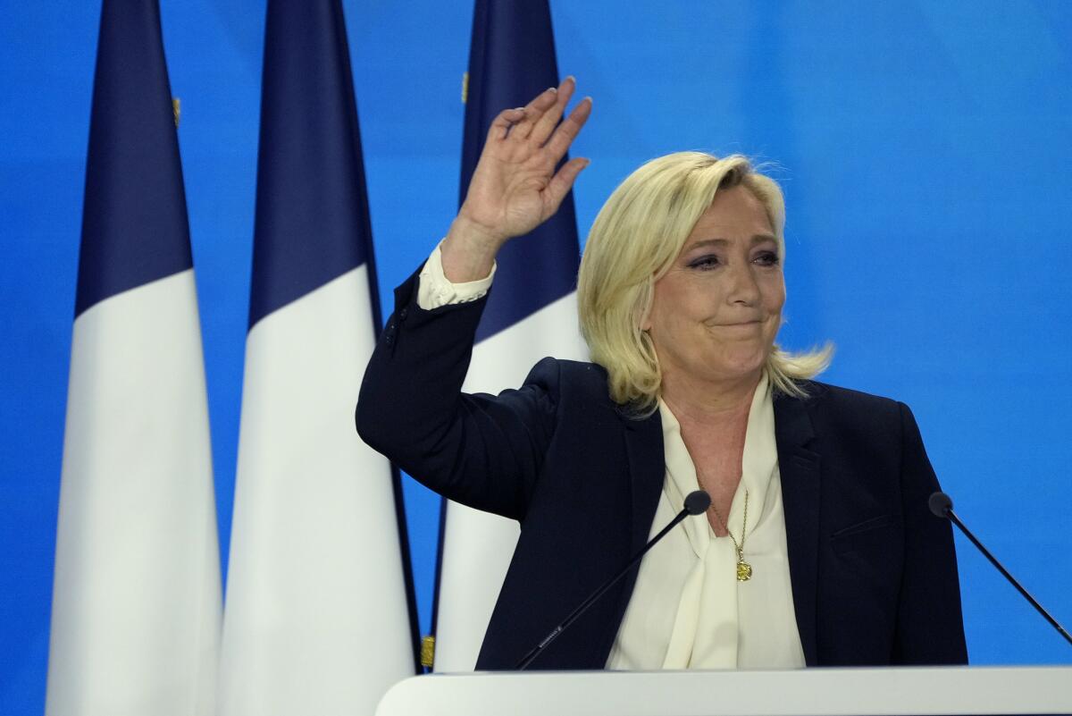 Marine Le Pen waves and makes a rueful face.