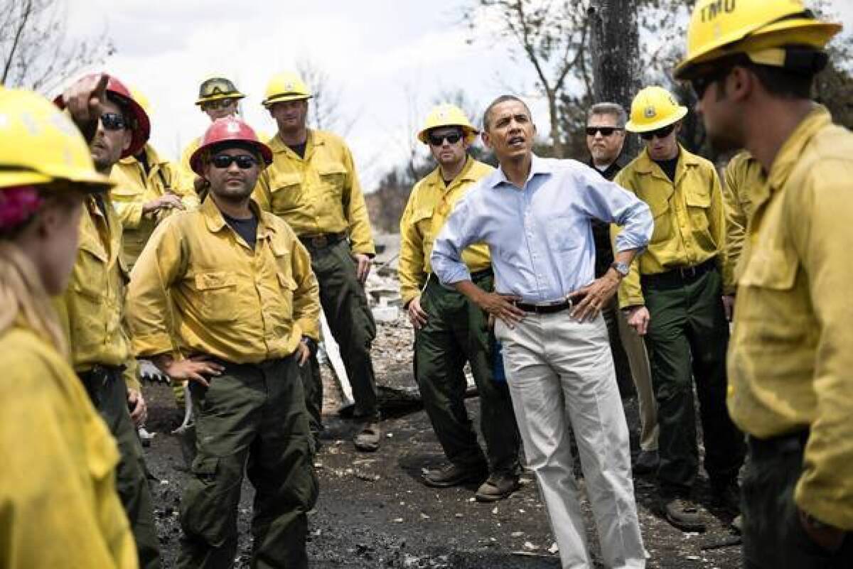President Obama talks with firefighters on a visit to the destroyed Mountain Shadow neighborhood of Colorado Springs, Colo.