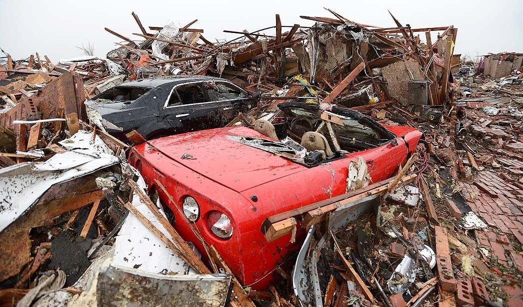 A destroyed Corvette sits in the rubble of a home in Moore, Okla.