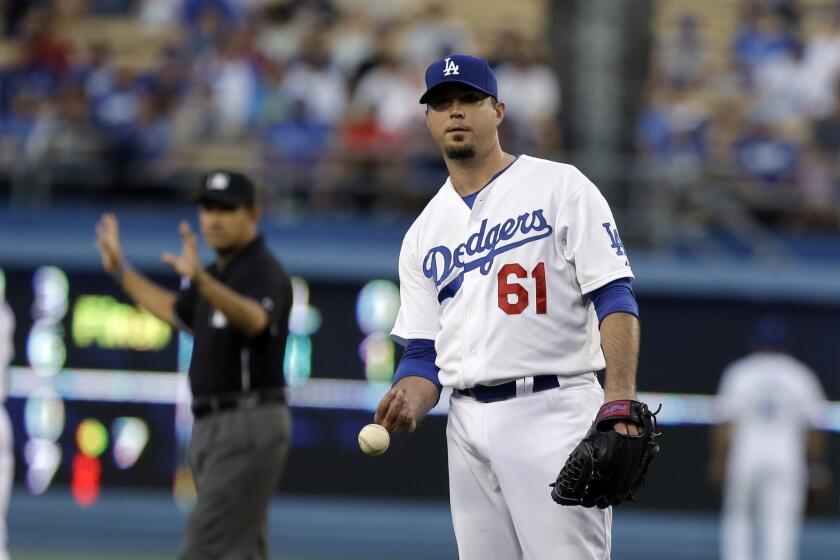 Dodgers pitcher Josh Beckett tosses the ball to the dugout after during the first inning.