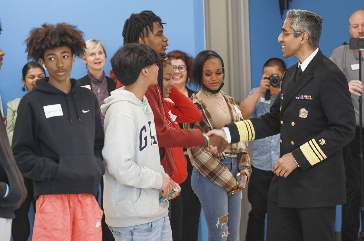 The U.S. surgeon general in uniform shakes hands with students