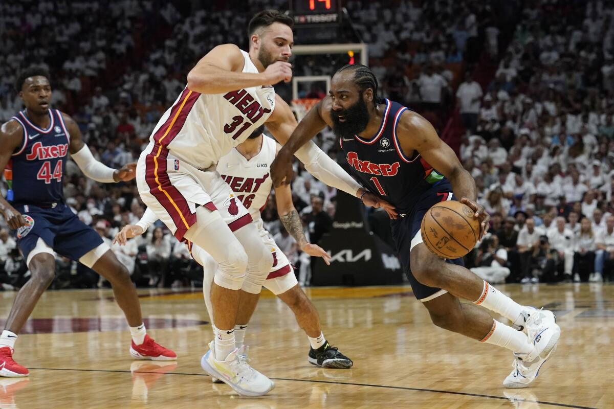 Heat guard Max Strus tries to cut off a drive by 76ers guard James Harden.