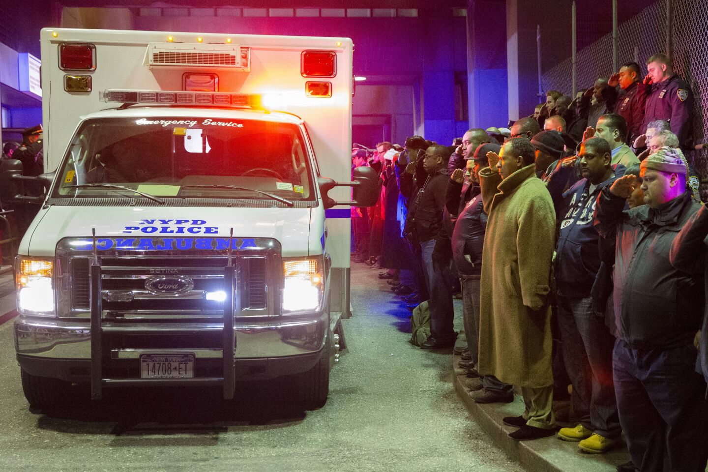 Mourners stand at attention as the bodies of Officers Rafael Ramos and Wenjian Liu are carried off in an ambulance.
