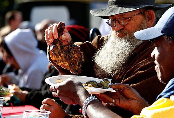 John O'Malley, 79, and Willie Scurry, 58, share a Christmas Eve meal at the Los Angeles Mission's annual Christmas Eve for the Homeless in downtown's skid row. Mission staff and volunteers dished up more than 3,000 meals for the homeless and for families in need. Toys for children were donated by JAKKS Pacific Inc., a designer and marketer of toys, and the Walt Disney Co.