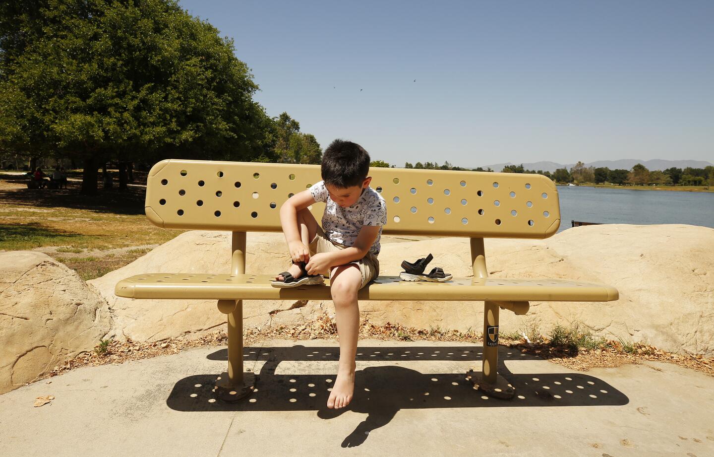 Kirill Matweer, 4, clears sand from his sh