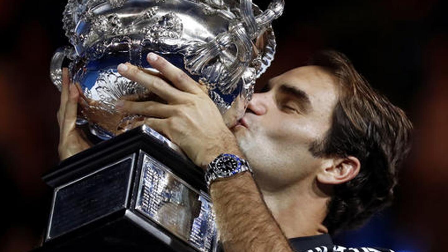 Roger Federer kisses the winner's trophy after defeating Rafael Nadal in the men's singles final at the Australian Open.