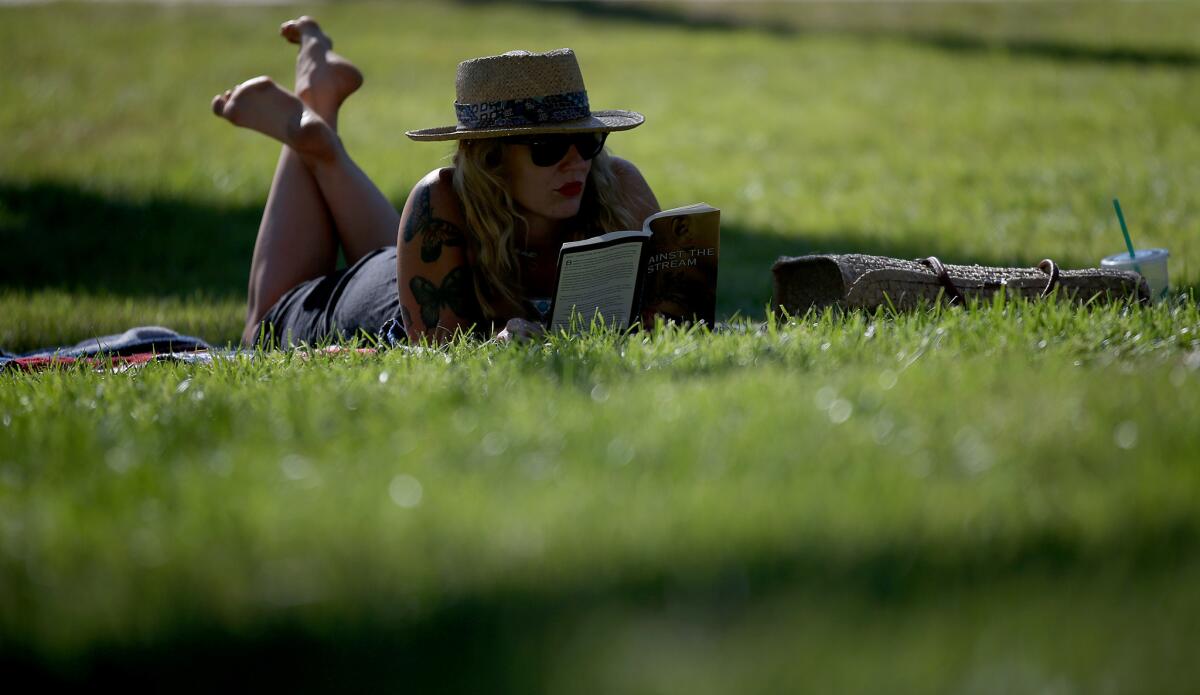 Angeleno Mishelle Parry reads at Echo Park Lake in June.