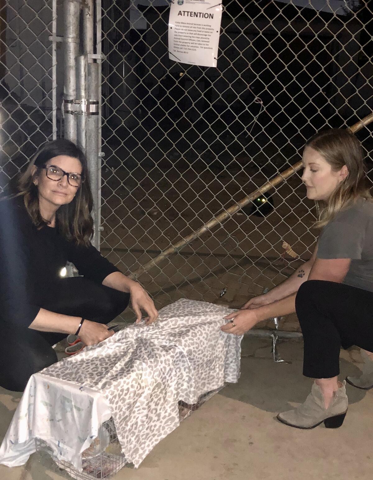 From left, TJ Kelley and Megan Robison prepare a trap with food.