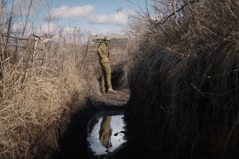 A Ukrainian serviceman pauses while walking to a frontline position outside Popasna, in the Luhansk region, eastern Ukraine, Sunday, Feb. 20, 2022. Russia extended military drills near Ukraine's northern borders Sunday amid increased fears that two days of sustained shelling along the contact line between soldiers and Russia-backed separatists in eastern Ukraine could spark an invasion. Ukraine's president appealed for a cease-fire. (AP Photo/Vadim Ghirda)