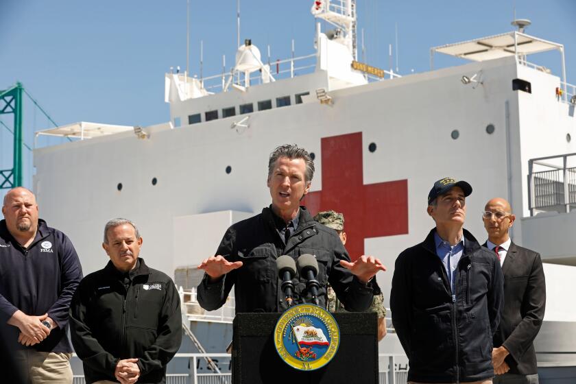 California Governor Gavin Newsom (C), flanked by (from L) Robert Fenton, FEMA Regional Administrator for Region 9, Director Mark Ghilarducci, Cal OES, Los Angeles Mayor Eric Garcetti, and Dr. Mark Ghaly, Secretary of Health and Human Services, speaks in front of the hospital ship USNS Mercy after it arrived into the Port of Los Angeles on March 27, 2020. - The USNS Mercy, a giant US naval hospital ship, arrived in Los Angeles on March 27, where it will be used to ease the strain on the city's coronavirus-swamped emergency rooms. (Photo by Carolyn Cole / POOL / AFP) (Photo by CAROLYN COLE/POOL/AFP via Getty Images)