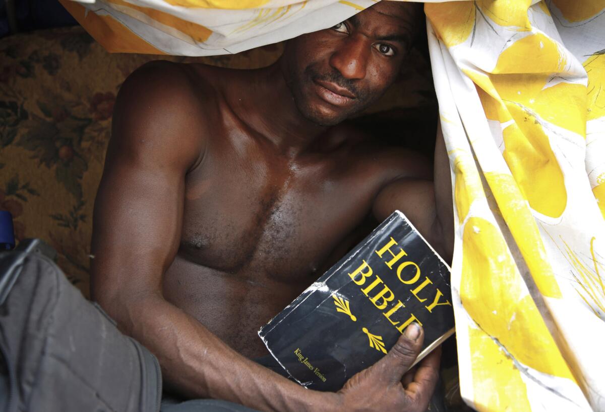 Terrion Brown holds the Bible, a belonging he keeps that is important to him. Brown, age 27, lives in a makeshift tent on skid row.