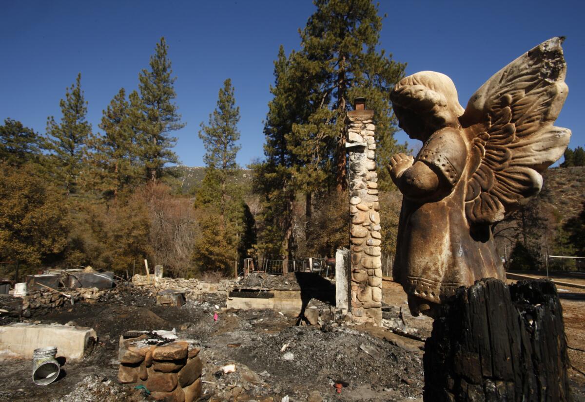 A ceramic angel stands watch over the charred debris at the cabin on Seven Oaks Road in Angelus Oaks where murder suspect and former cop Christopher Dorner died after a shootout with police.