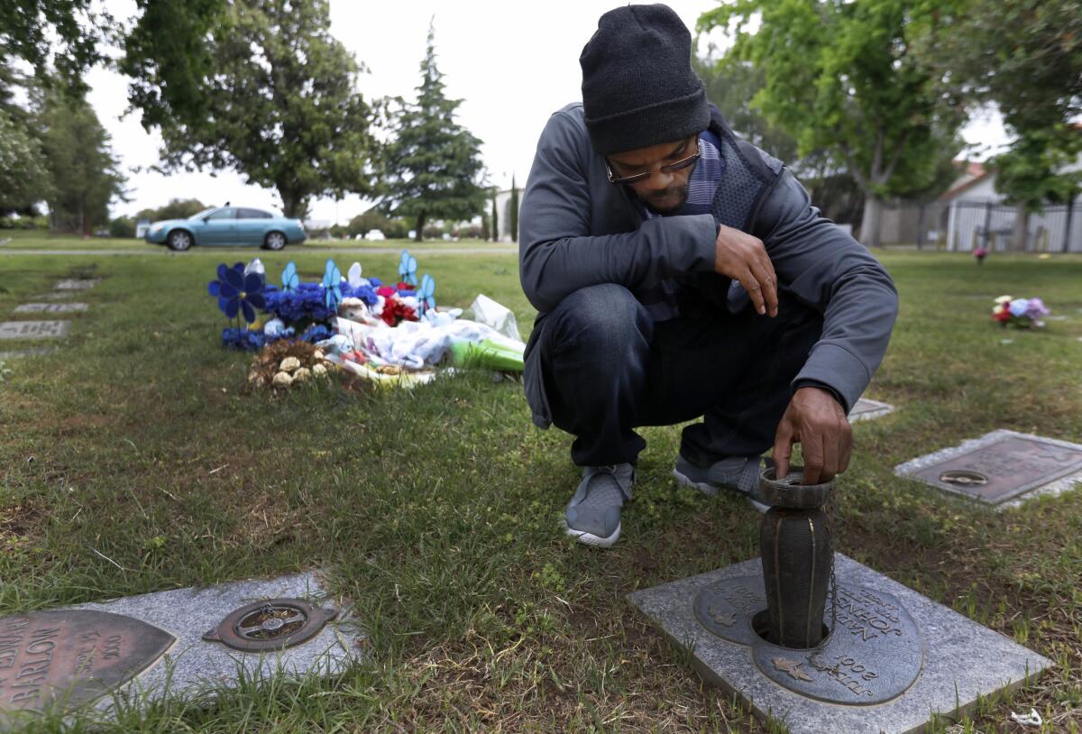 Zavion Johnson visits his daughter's grave in Sacramento. Johnson was convicted of second-degree murder in the 2001 death of his 4-month-old daughter, Nadia Dyvine Johnson. He was exonerated in 2017 and released from prison after 16 years.