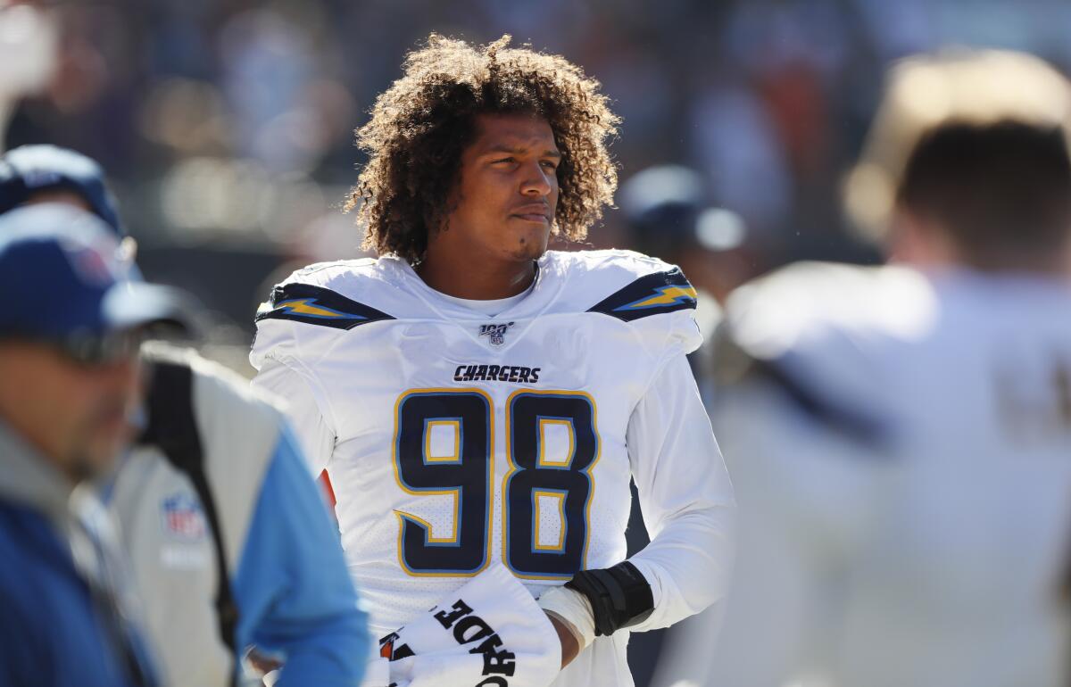 Chargers defensive lineman Isaac Rochell looks on from the sidelines during a game.