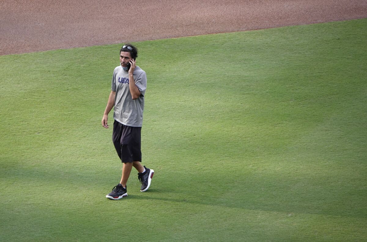 Padres General Manager A.J. Preller talks on the phone as he crosses the Petco Park infield.