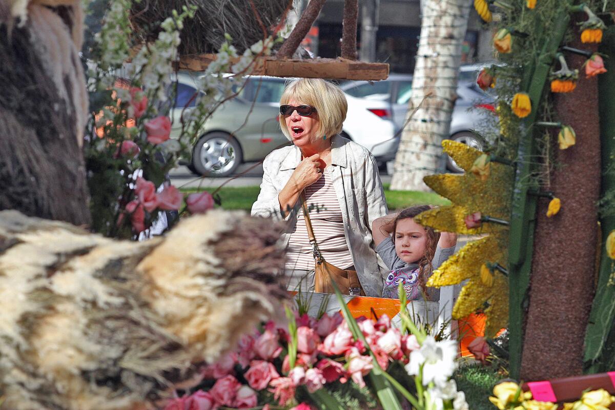 Leah Kamm of Los Feliz holds the hand of her grand daughter Mia Friedlander, 5, of Encino, as they look at the front of the Glendale Rose Parade float, set for viewing on Brand Blvd. in front of the Alex Theatre, on Friday, January 3, 2014.