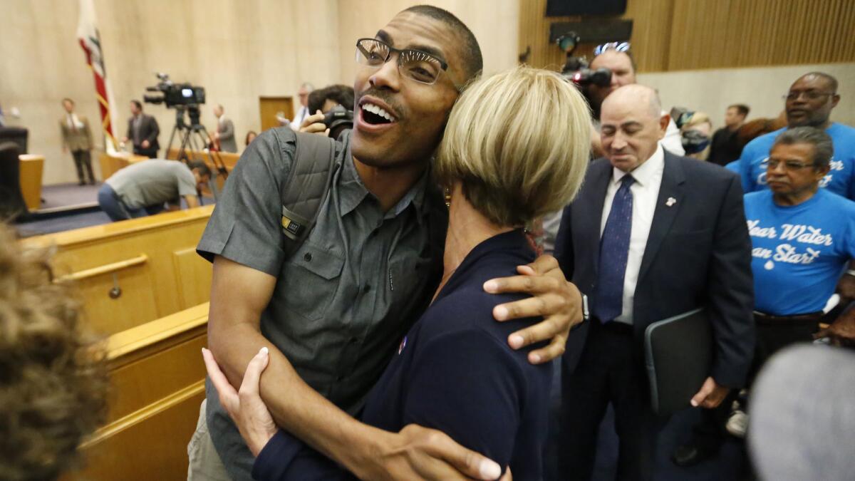 Compton Commissioner Rodney Andrews, left, reacts after county authorities voted unanimously to dissolve the troubled water agency.