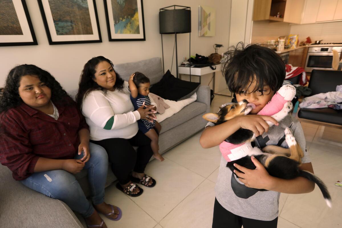 Natalie Quintanilla, and her children Victoria, 11, from left, Patrick, 1 1/2, and Mason, 5, holding the family dog Lassie.