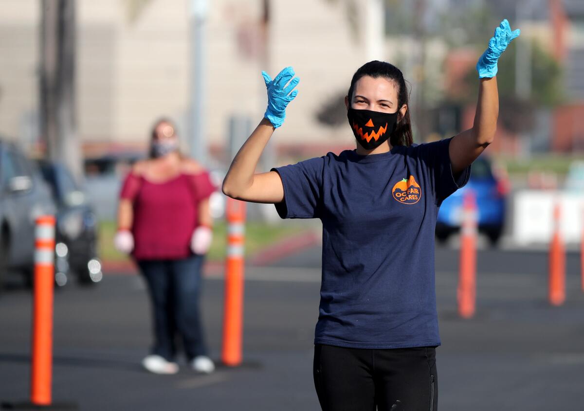 Stefanie da Silva, 27, of Huntington Beach, helps guide vehicles at the Power of One Foundation Thanksgiving food giveaway.