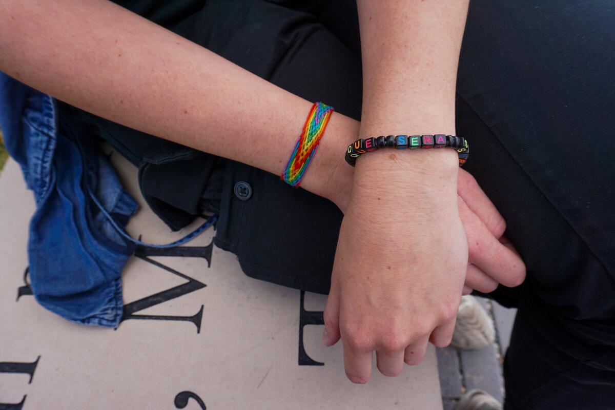 Two arms are crossed at the wrist.