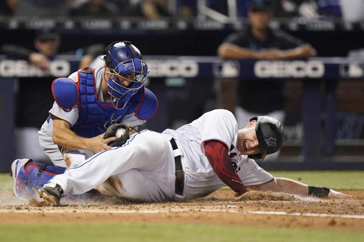 Miami Marlins' Garrett Cooper is tagged out at home by Dodgers catcher Austin Barnes.