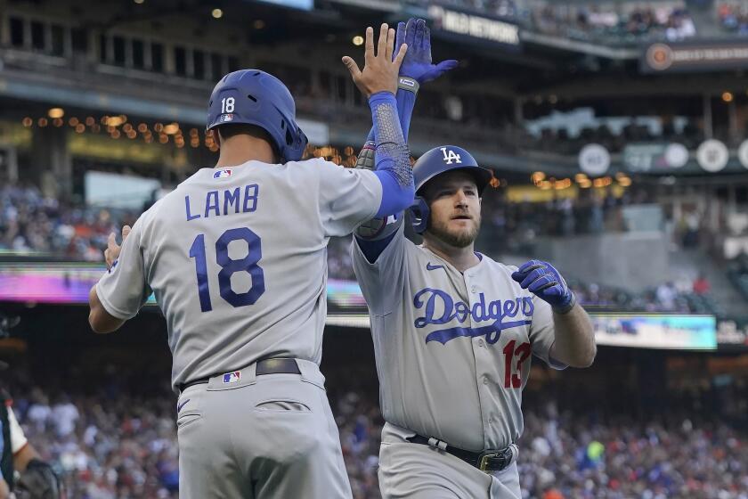 Los Angeles Dodgers' Max Muncy, right, celebrates after hitting a two-run home run that scored Jake Lamb (18) during the second inning of a baseball game against the San Francisco Giants in San Francisco, Monday, Aug. 1, 2022. (AP Photo/Jeff Chiu)
