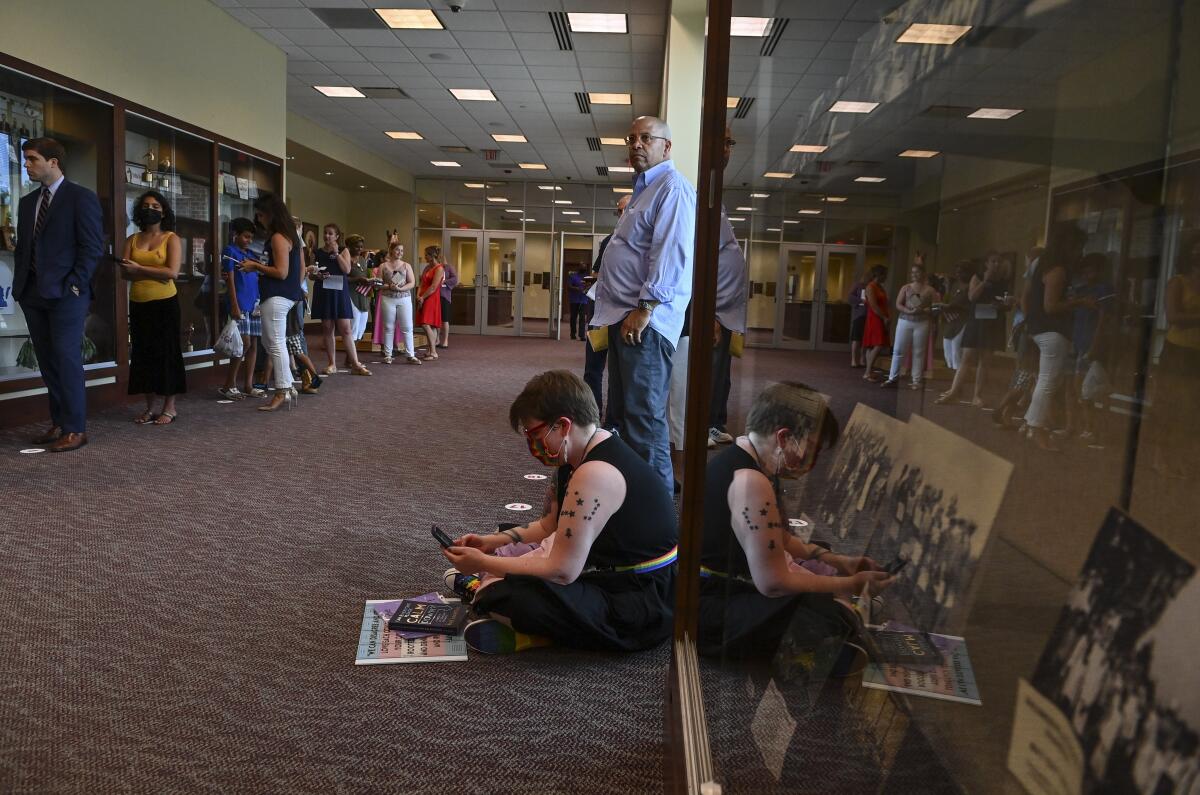 People wait in line to speak in person at the Loudoun County school board meting on August 10, 2021 in Ashburn, Va. 