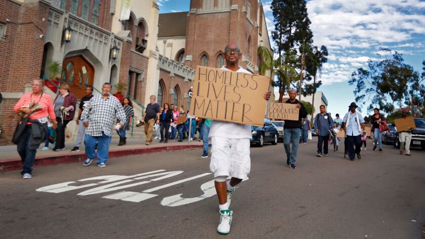 In this file photo from 2017, Carlton Dixon walks in a procession during a San Diego Rescue Mission memorial and celebration of life for the 116 homeless individuals who lost their lives on the streets in the previous year. A plan to help homeless people in San Diego will go before the City Council on Monday.