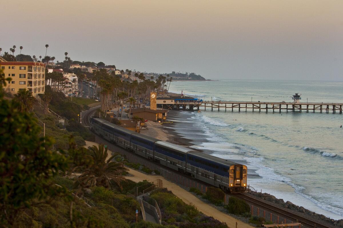 The Amtrak Pacific Surfliner train travels past the the San Clemente pier at sunset. Cheapair.com is offering Amtrak alternatives to airline reservations.