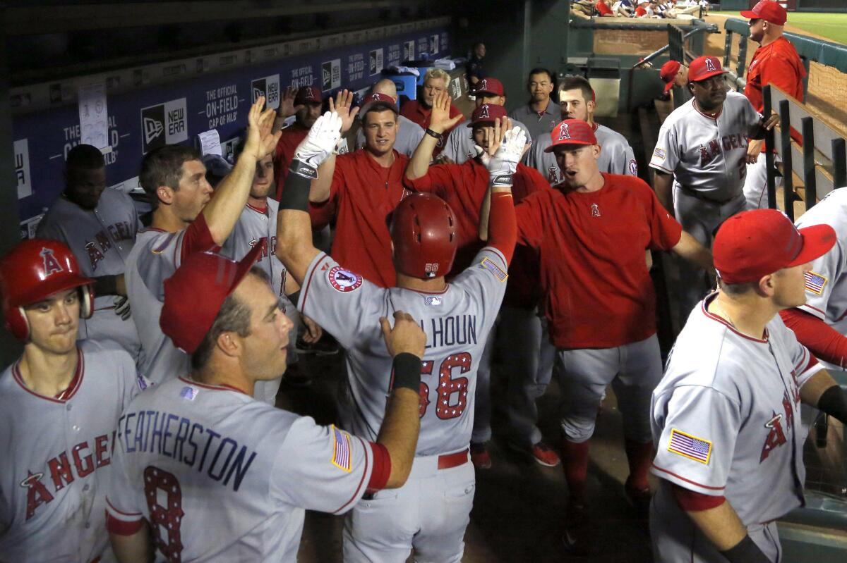 Angels' Kole Calhoun is congratulated in the dugout after hitting a solo home run in the fourth inning Saturday against Texas.